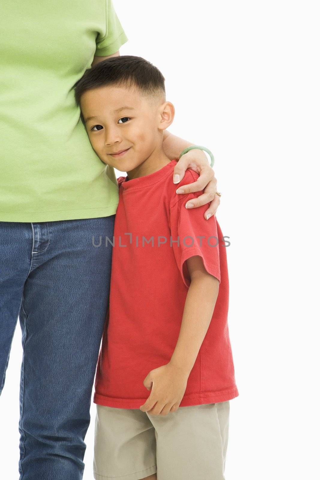 Asian mother standing with arm around son.