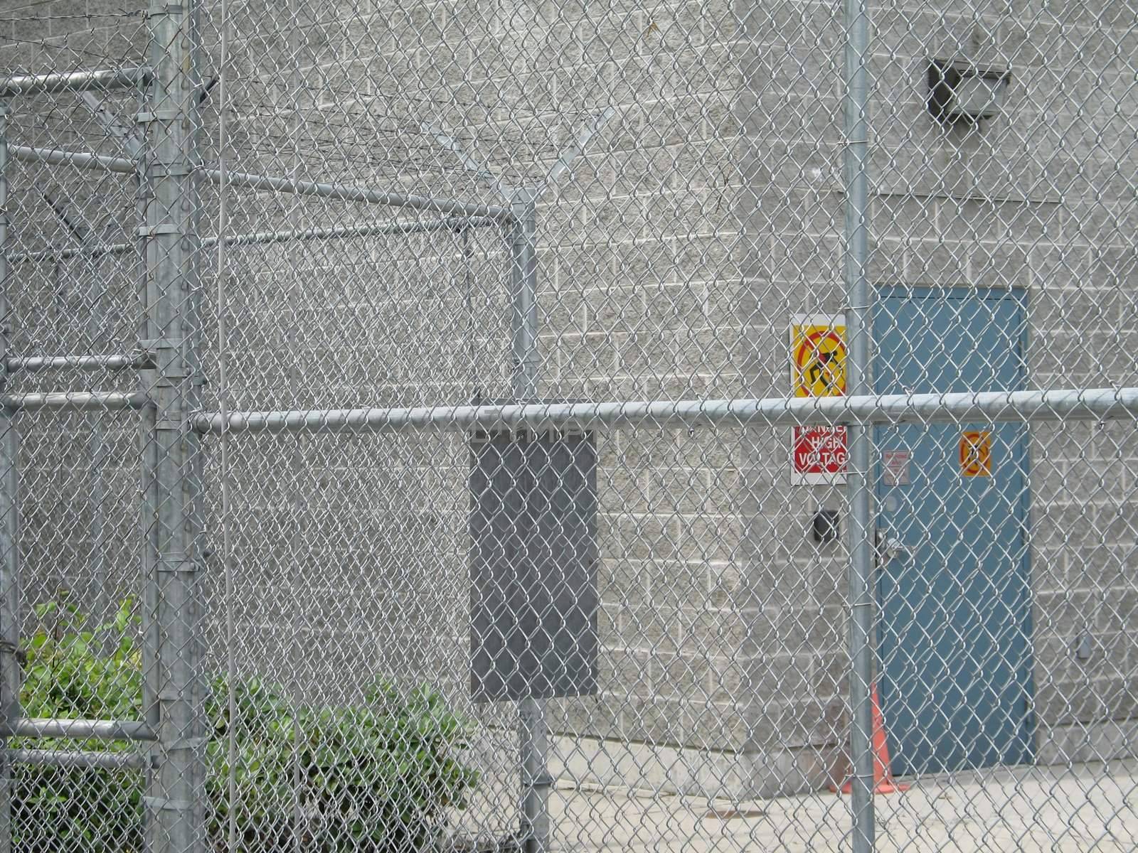 industrial building behind a fence by mmm