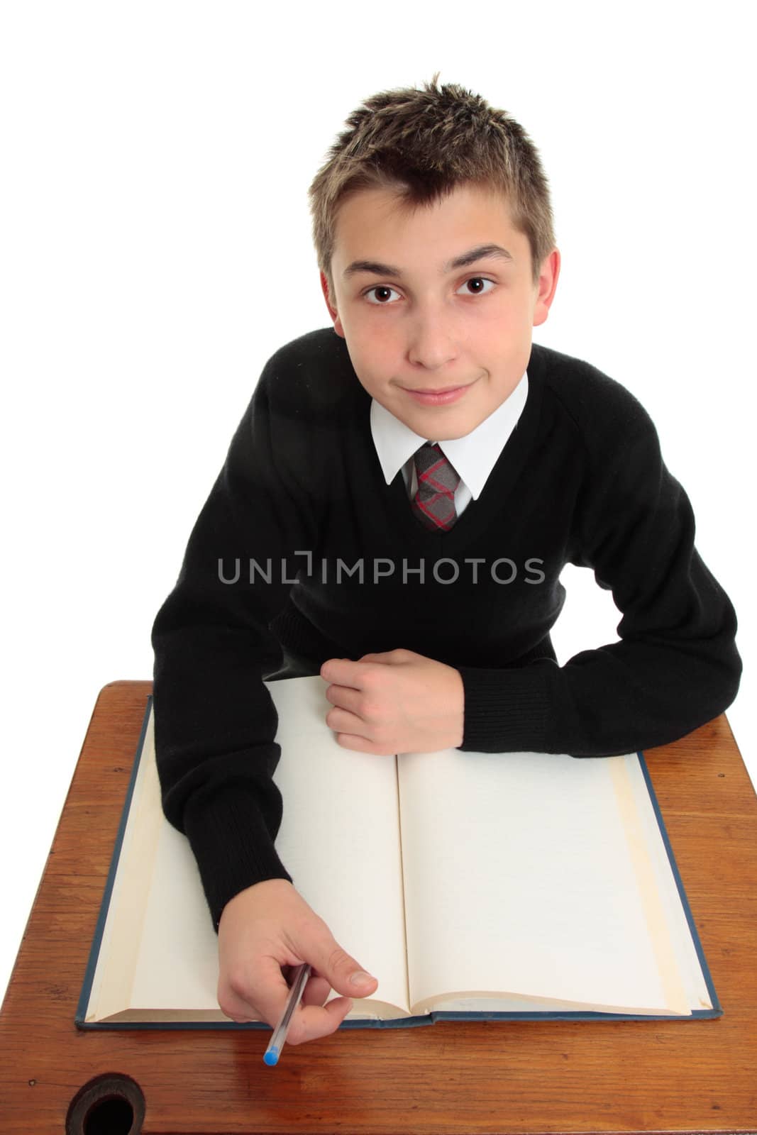 Young high school student looking up with open book at desk.