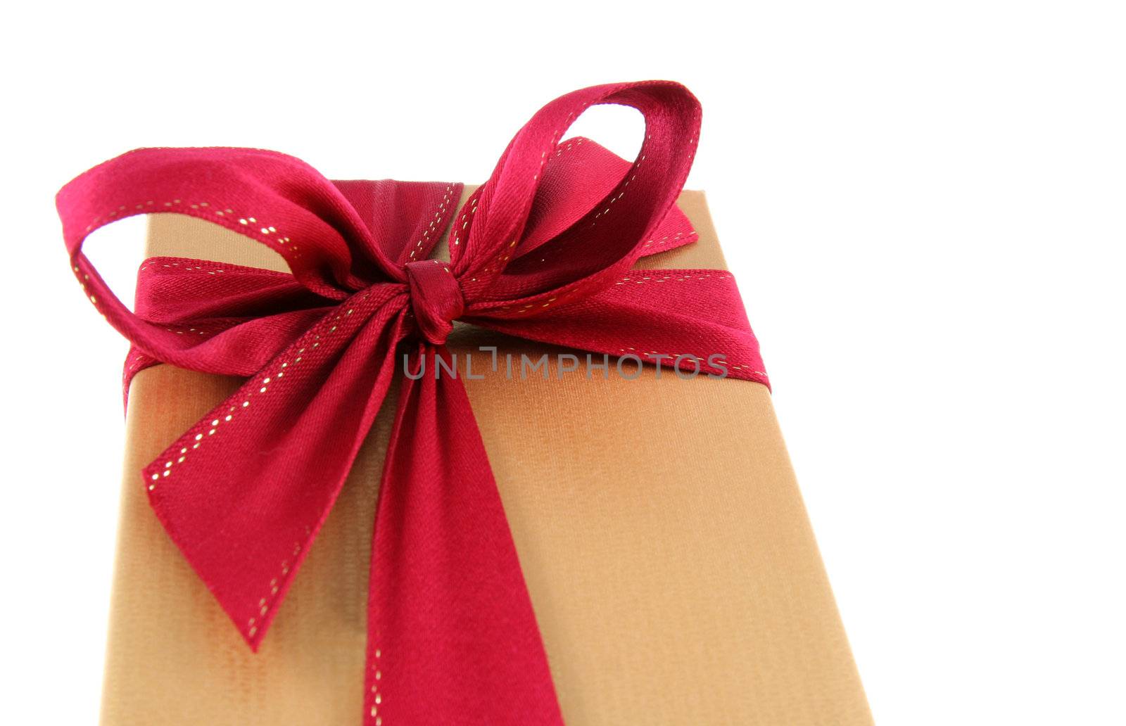 A Christmas present wrapped in gold paper with red ribbon.
