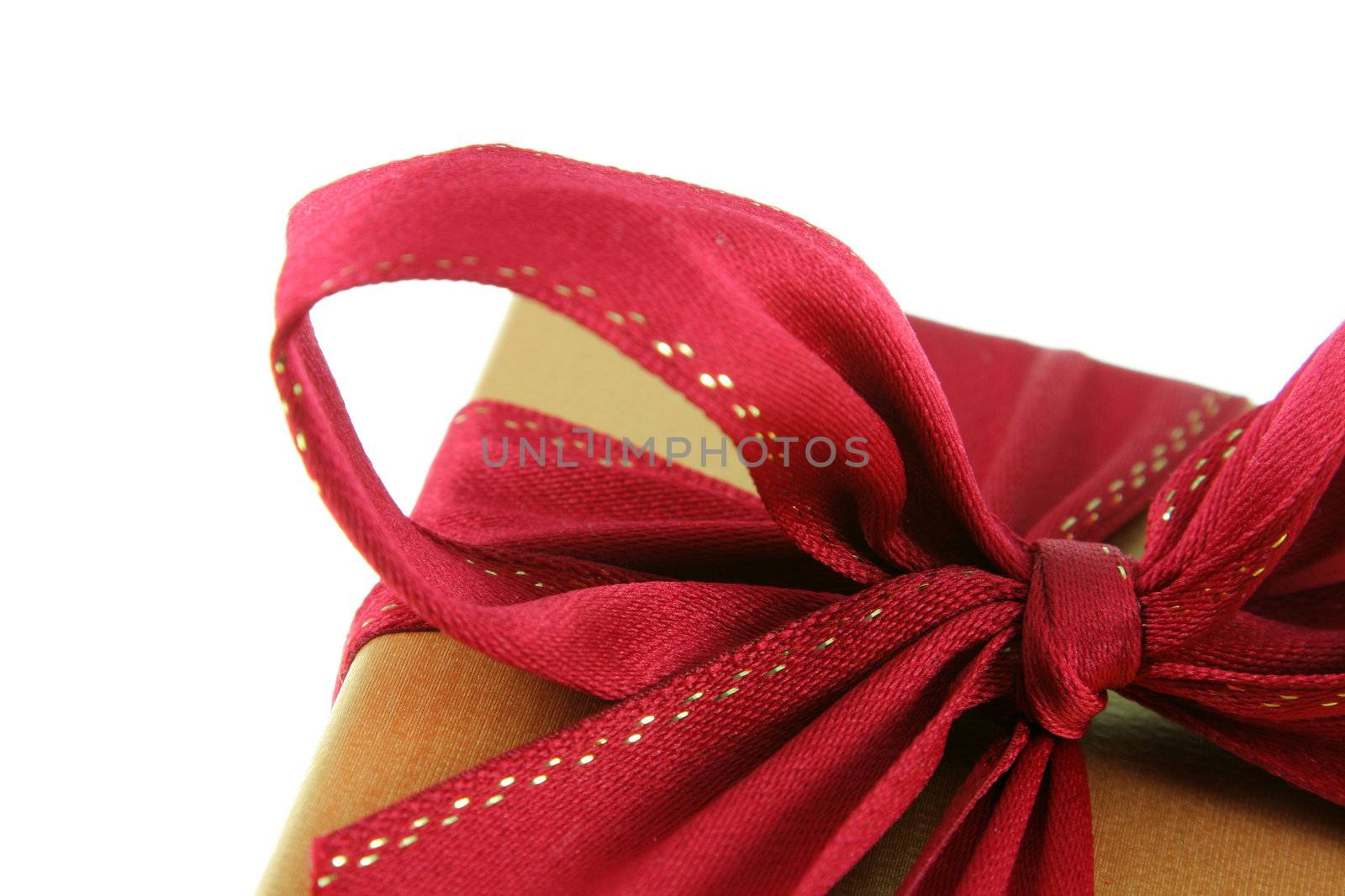 A Christmas present wrapped in gold paper with red ribbon.
