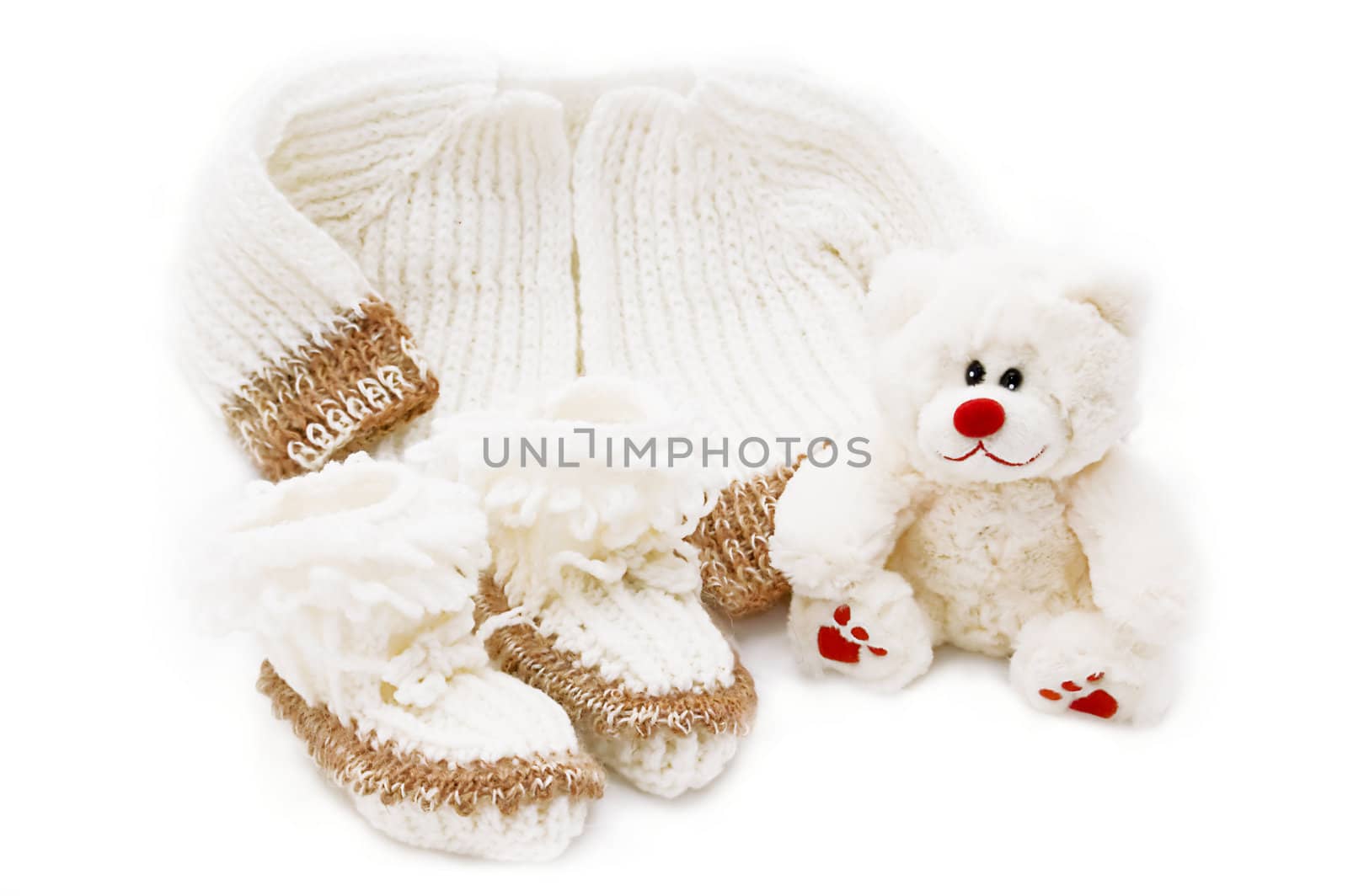 wool hand-made baby coat, socks and teddy bear over white