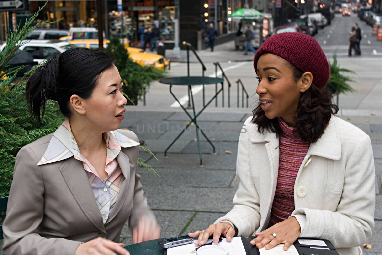 Two business women having a casual meeting or discussion in the city. 
