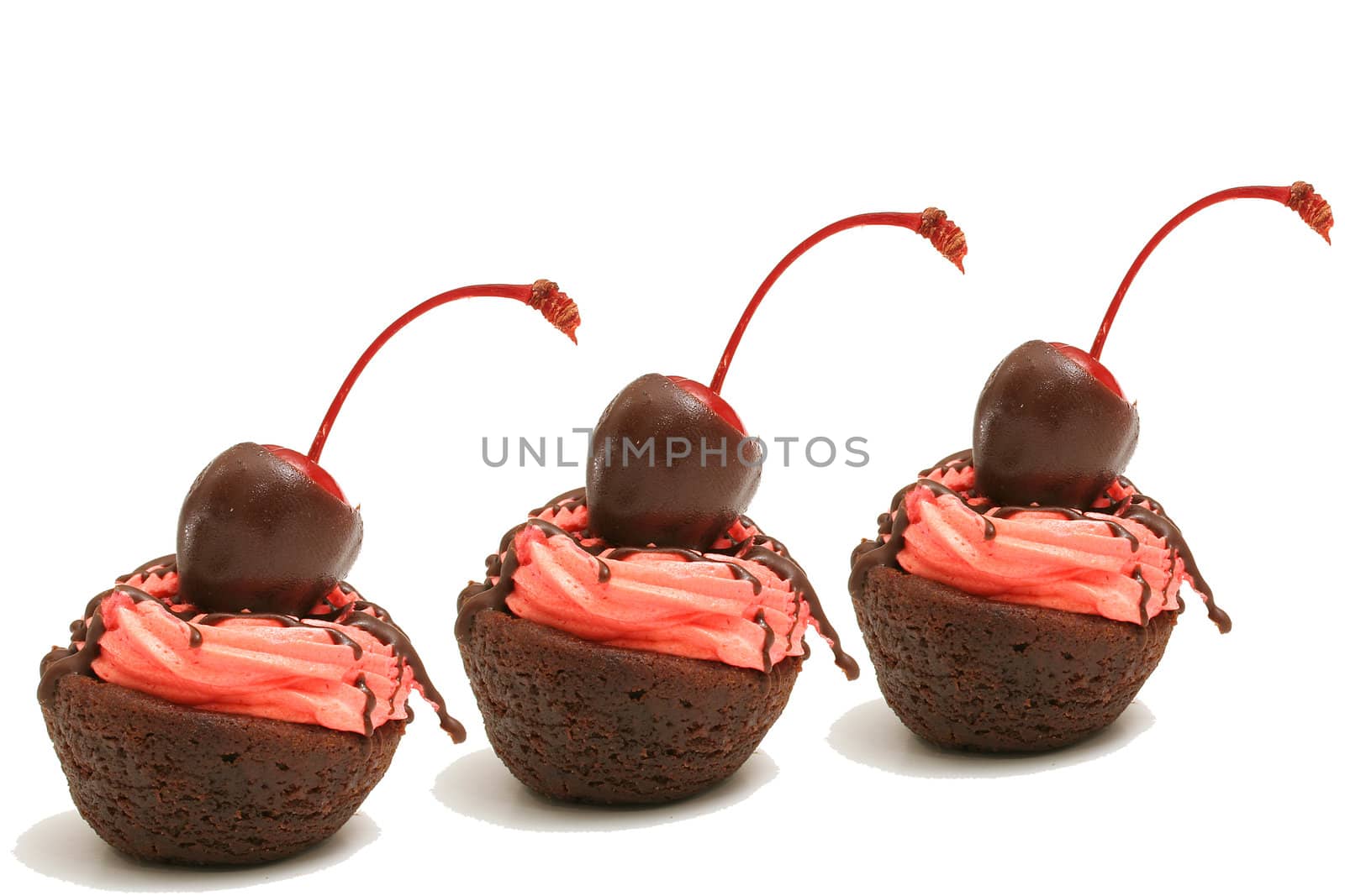 Three brownie bites in a row isolated on white by creativestock