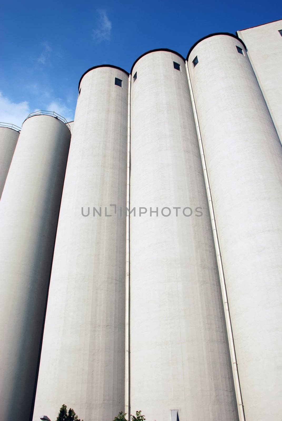 White tall industrial silo tower over blue sky