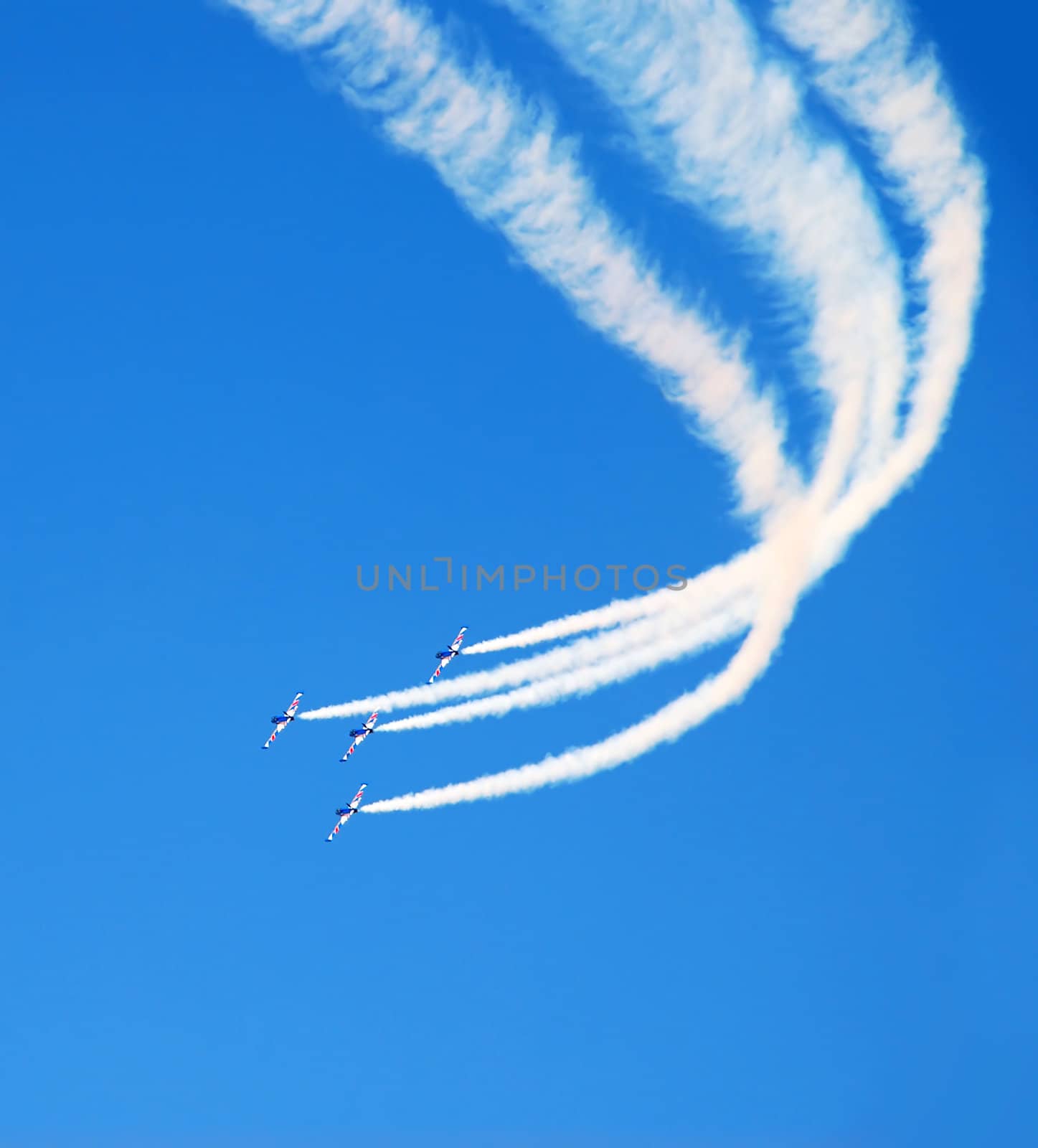 planes group in acrobatic flight with smoke trace over blue sky