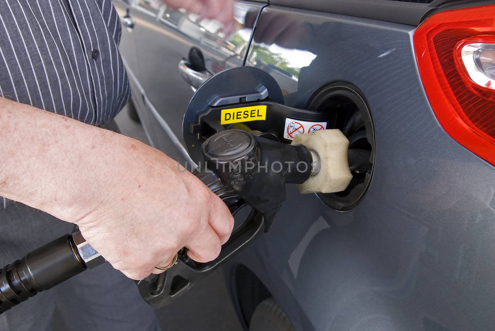 Close-up of a man�s hand using a petrol pump to fill his car up with fuel