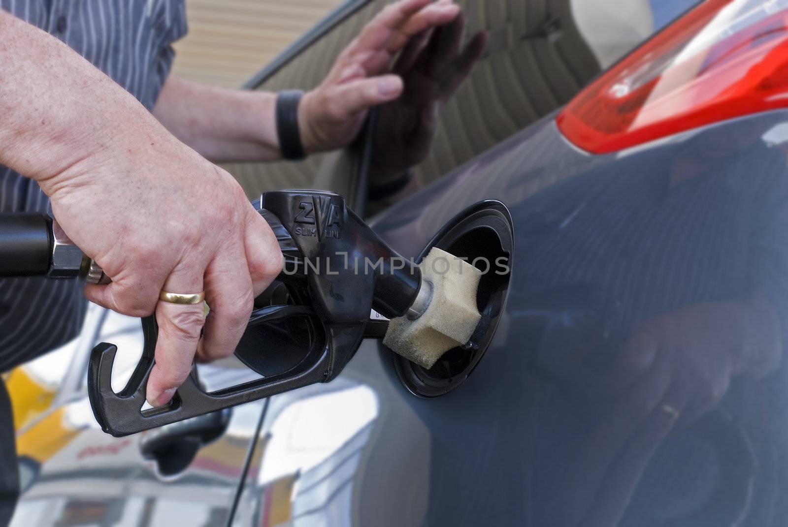 Close-up of a man�s hand using a petrol pump to fill his car up with fuel