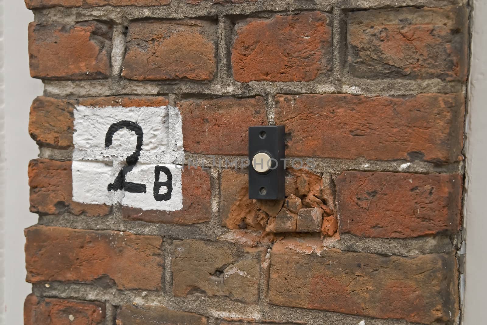 Housenumber sign painted on brick wall