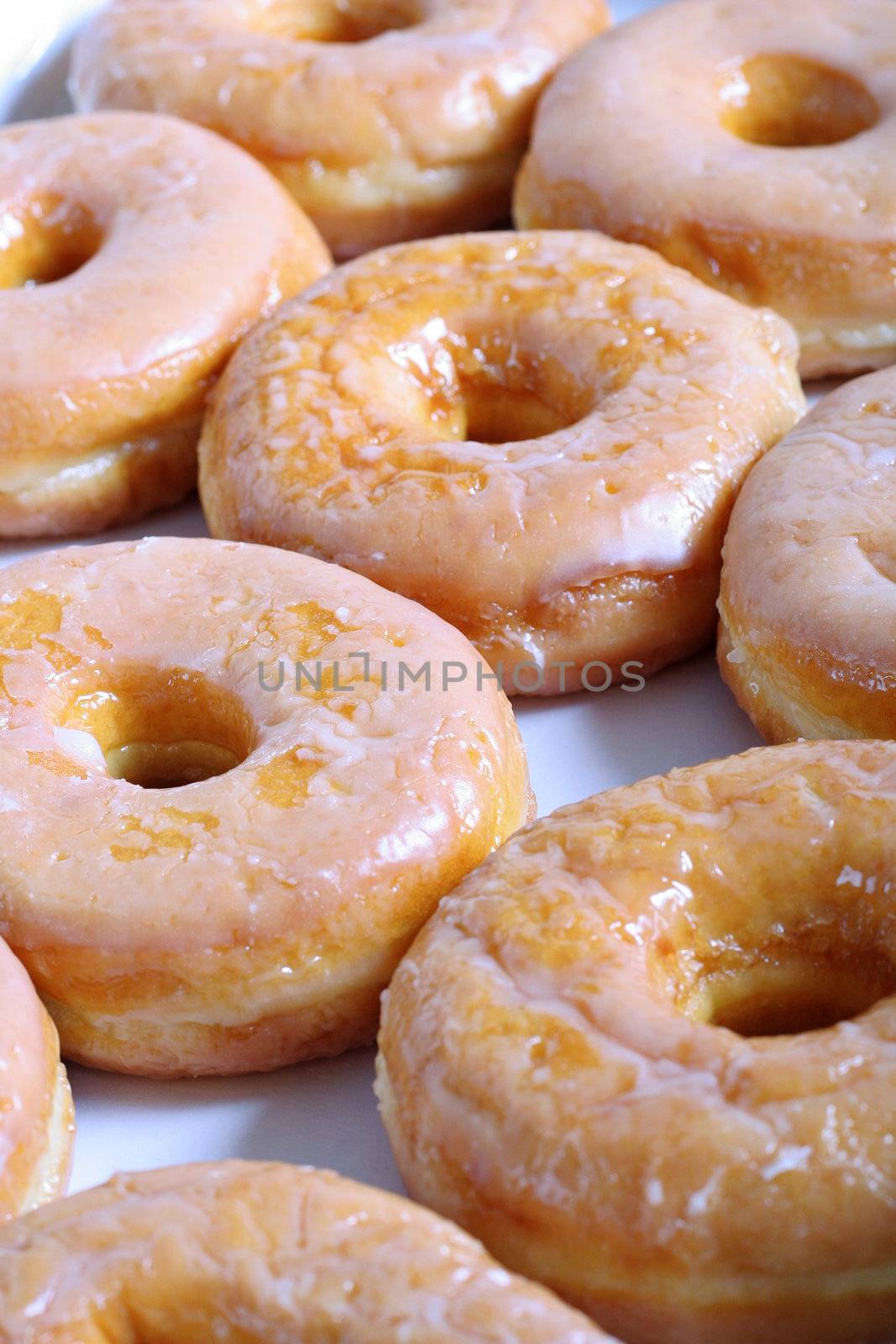 shot of glazed doughnuts vertical by creativestock