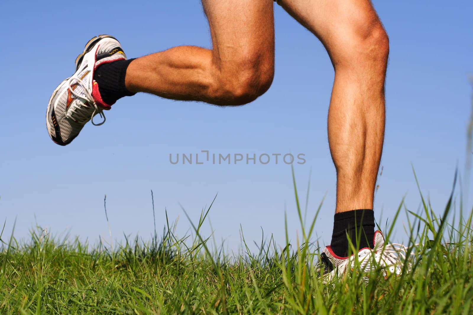Iconic running image. Freeze action closeup of running shoes and legs in action.