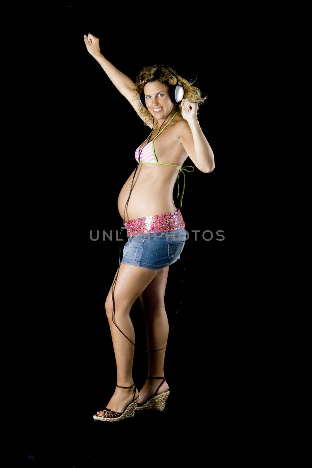 Beautiful and young pregant woman liesten music whit head phones