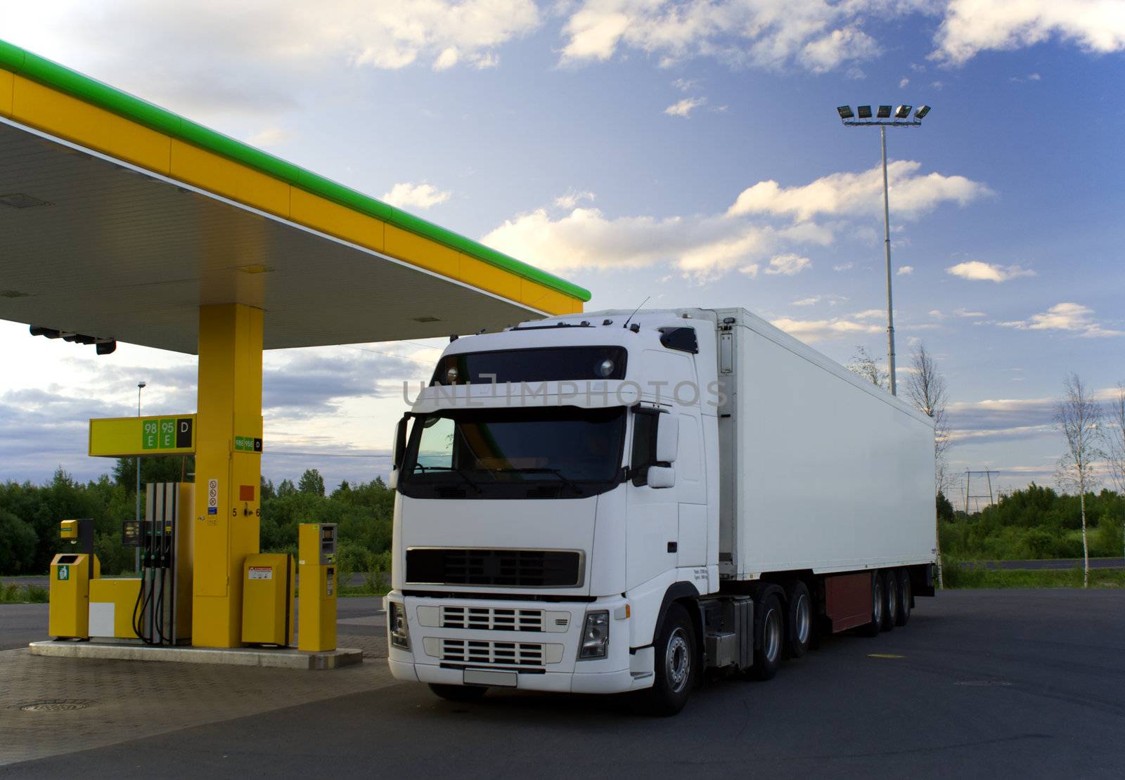 White truck is at a fuel station.