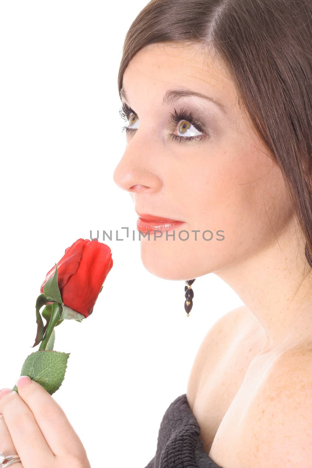 brunette smelling a rose looking up isolated on white by creativestock
