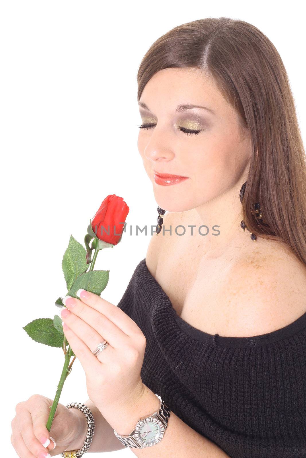 shot of a brunette smelling a rose by creativestock