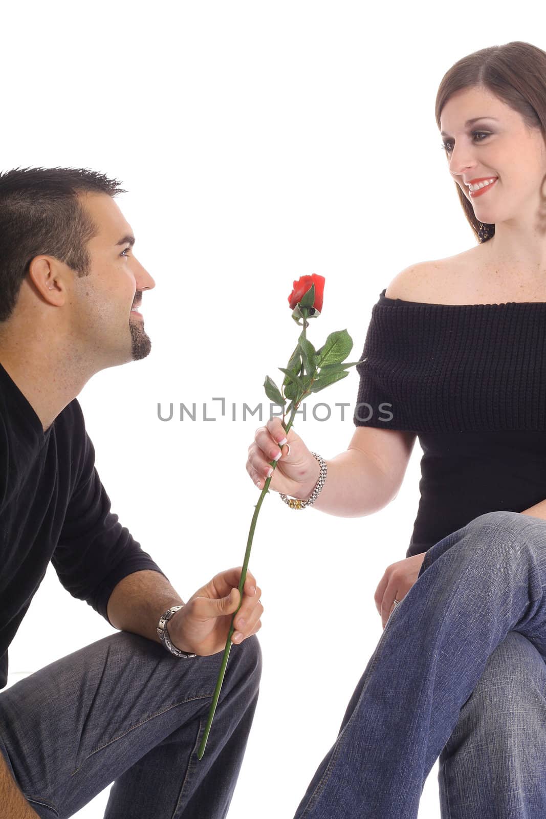 latino man giving woman a rose isolated on white by creativestock