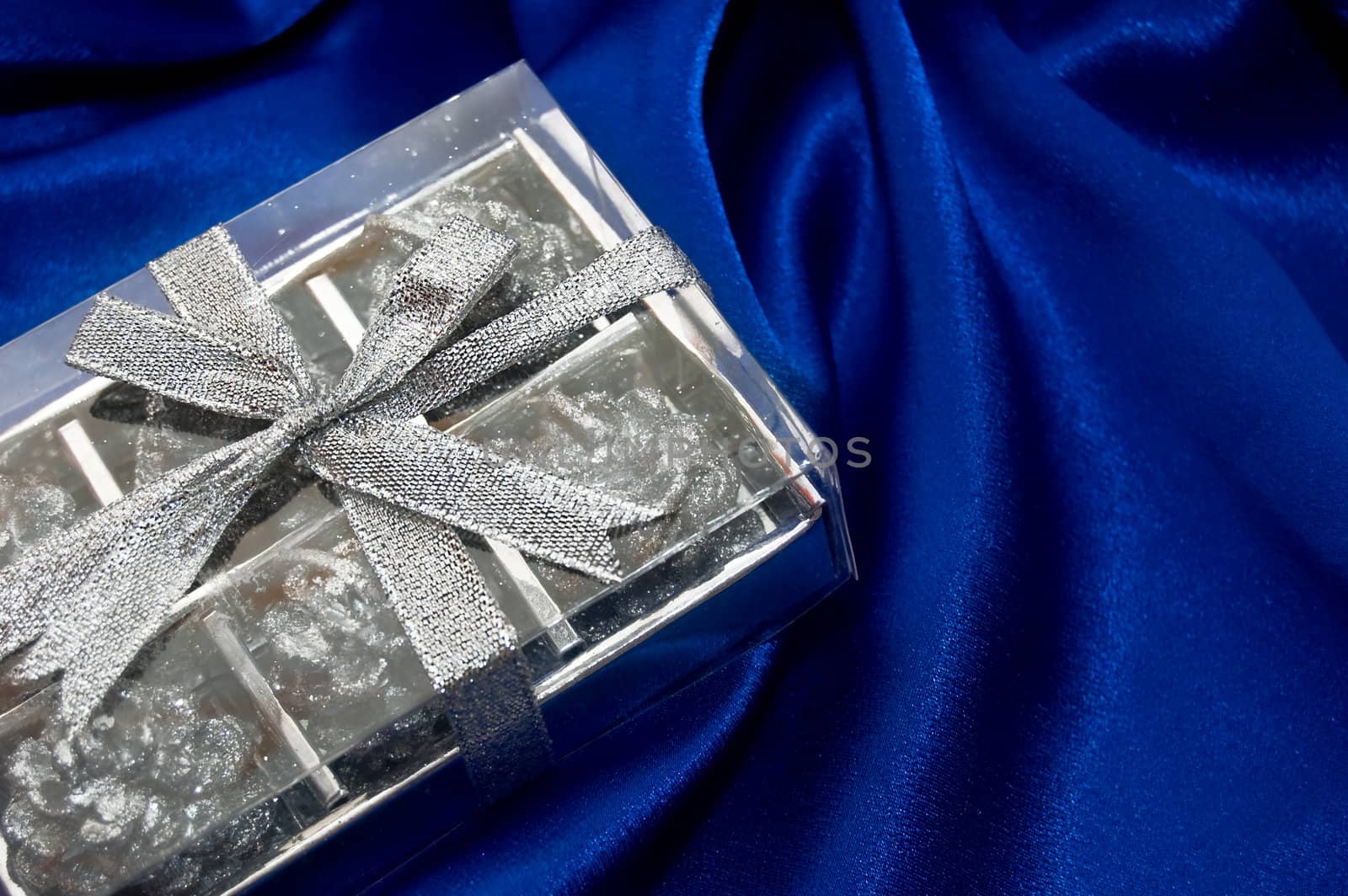 silver gift box on blue satin fabric