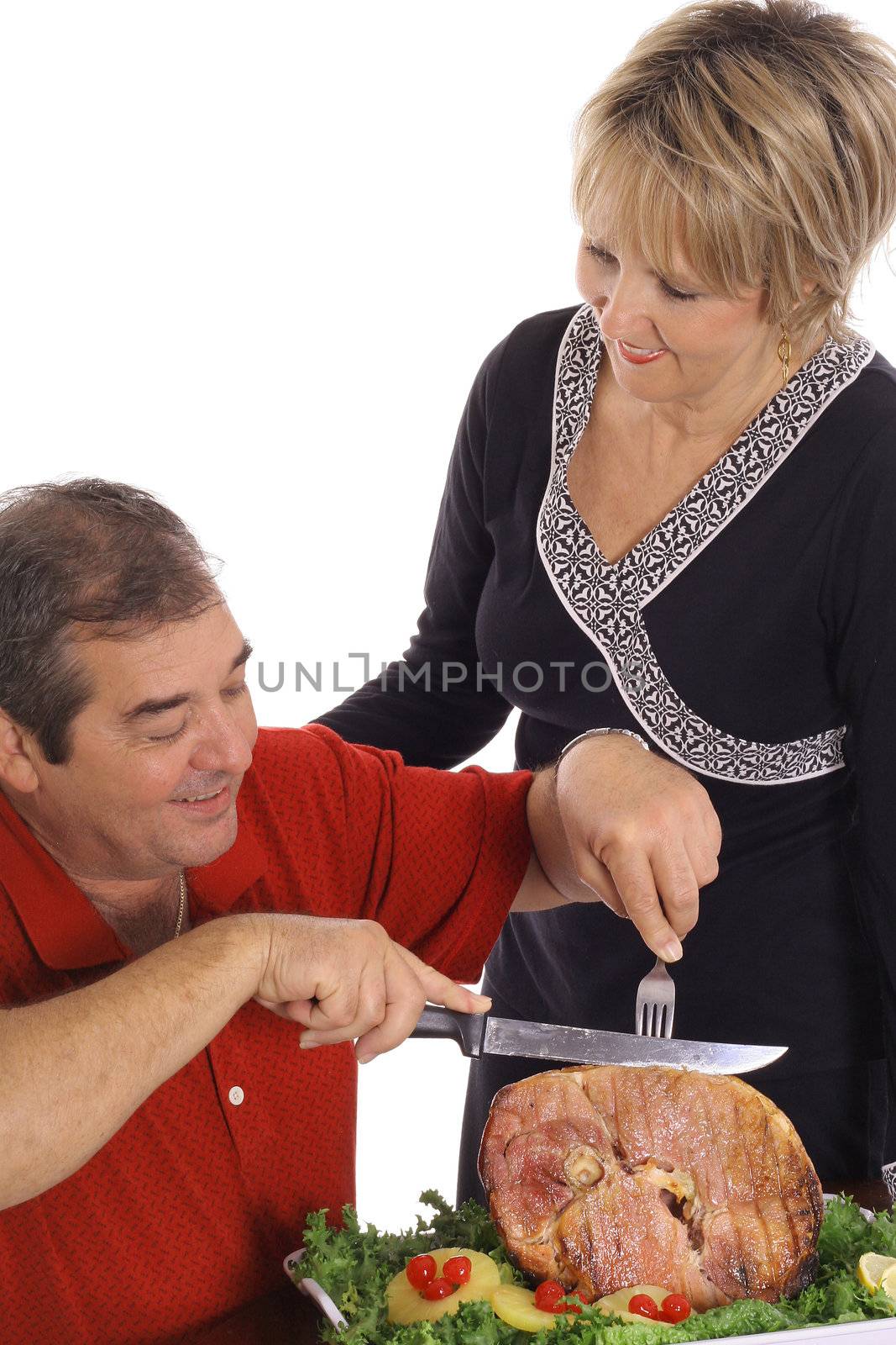 middle aged couple slicing ham