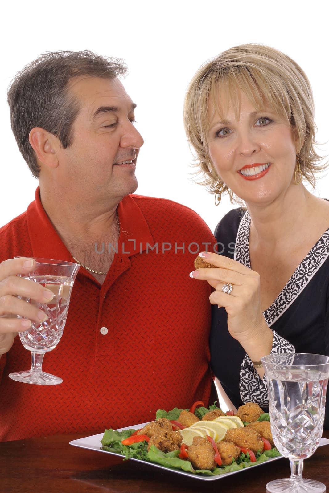 middle aged couple having appetizers vertical isolated on white by creativestock