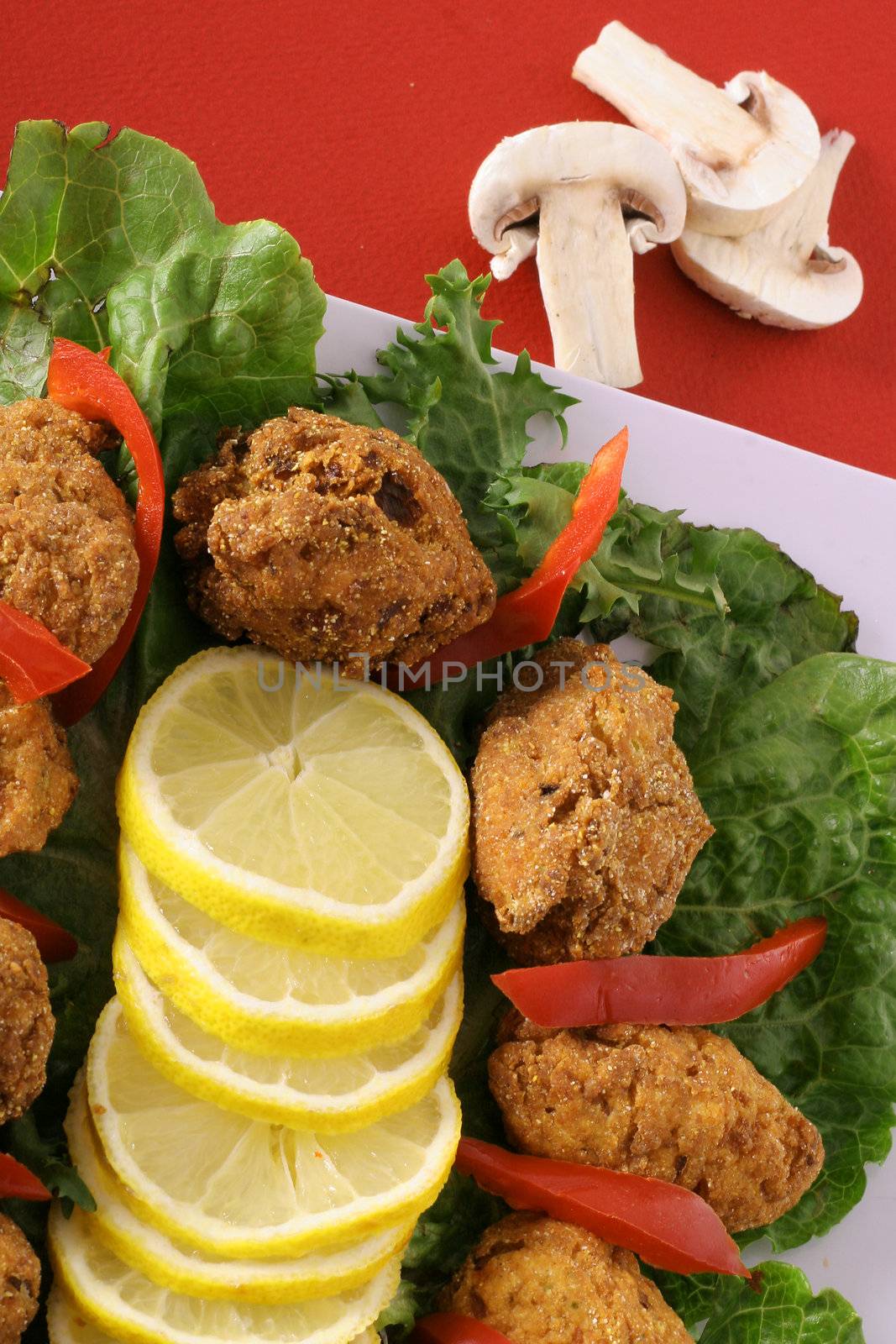 shot of crab cakes and lemon slices by creativestock