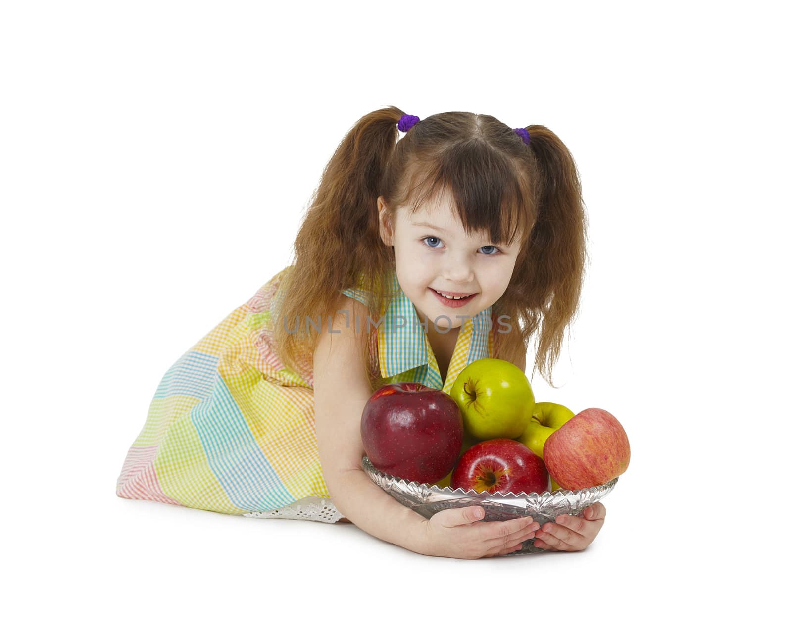 A little girl with a glass dish full of apples