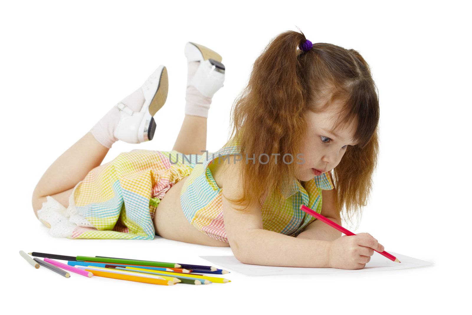 Little girl lying on the floor, drawing with crayons