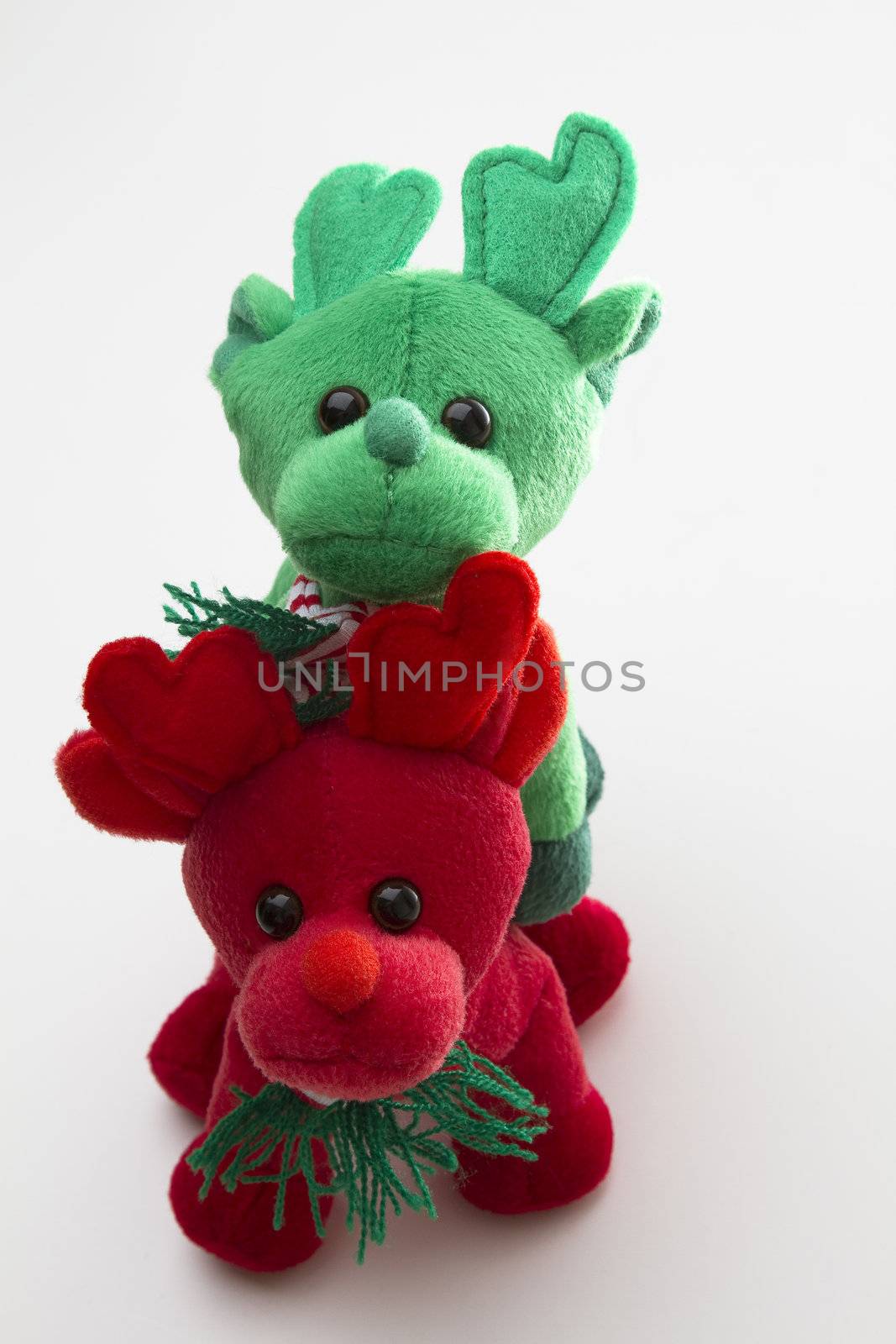 red and green toy reindeer standing one on top of the other
