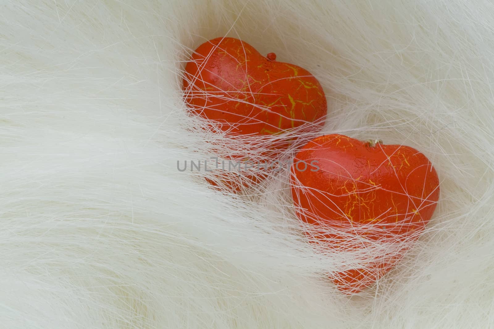 Two red wood hearts  lie on the fur