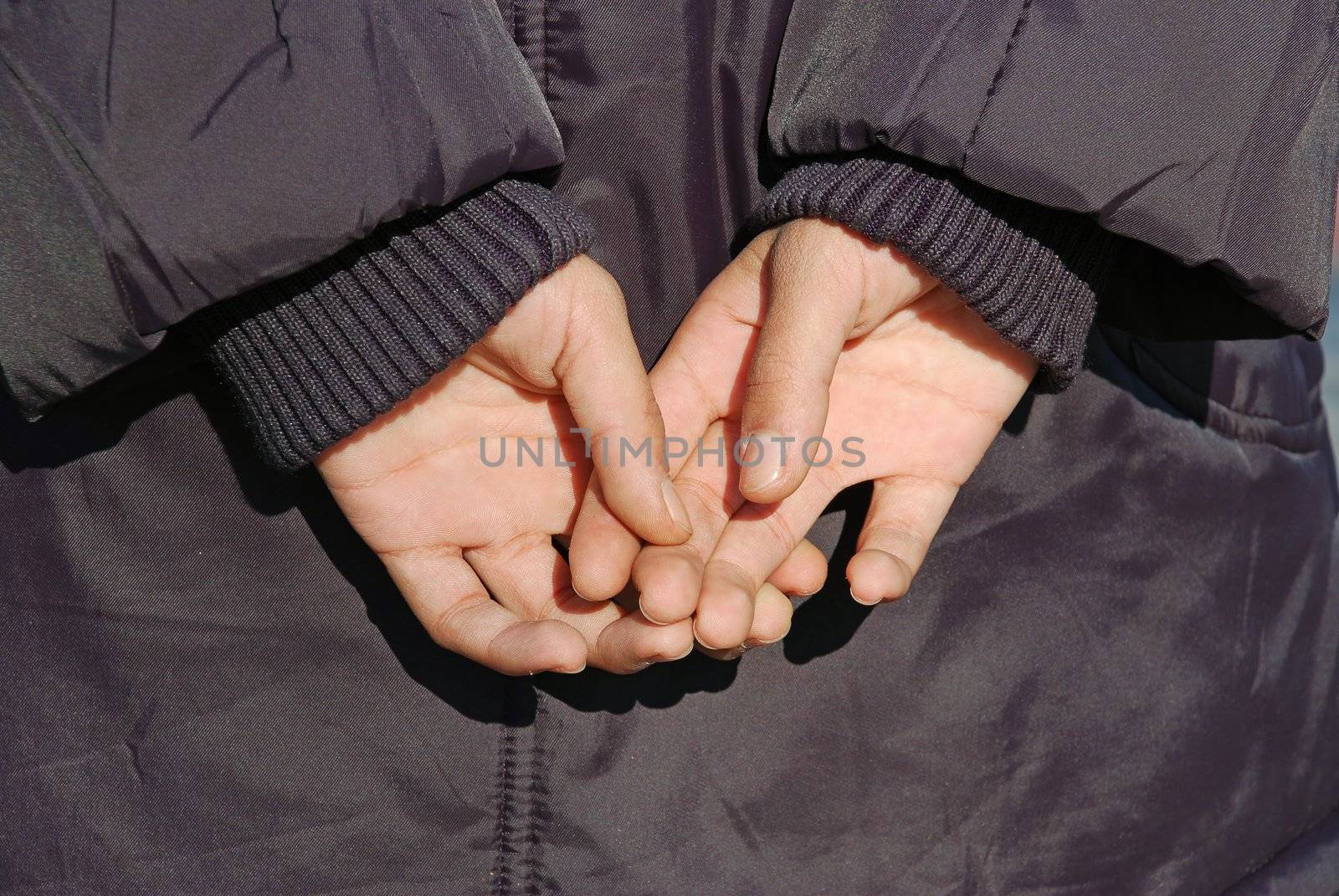 child hands in jacket on back closeup
