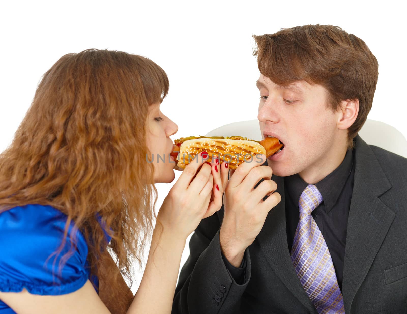 Man and woman eating a sausage in the roll