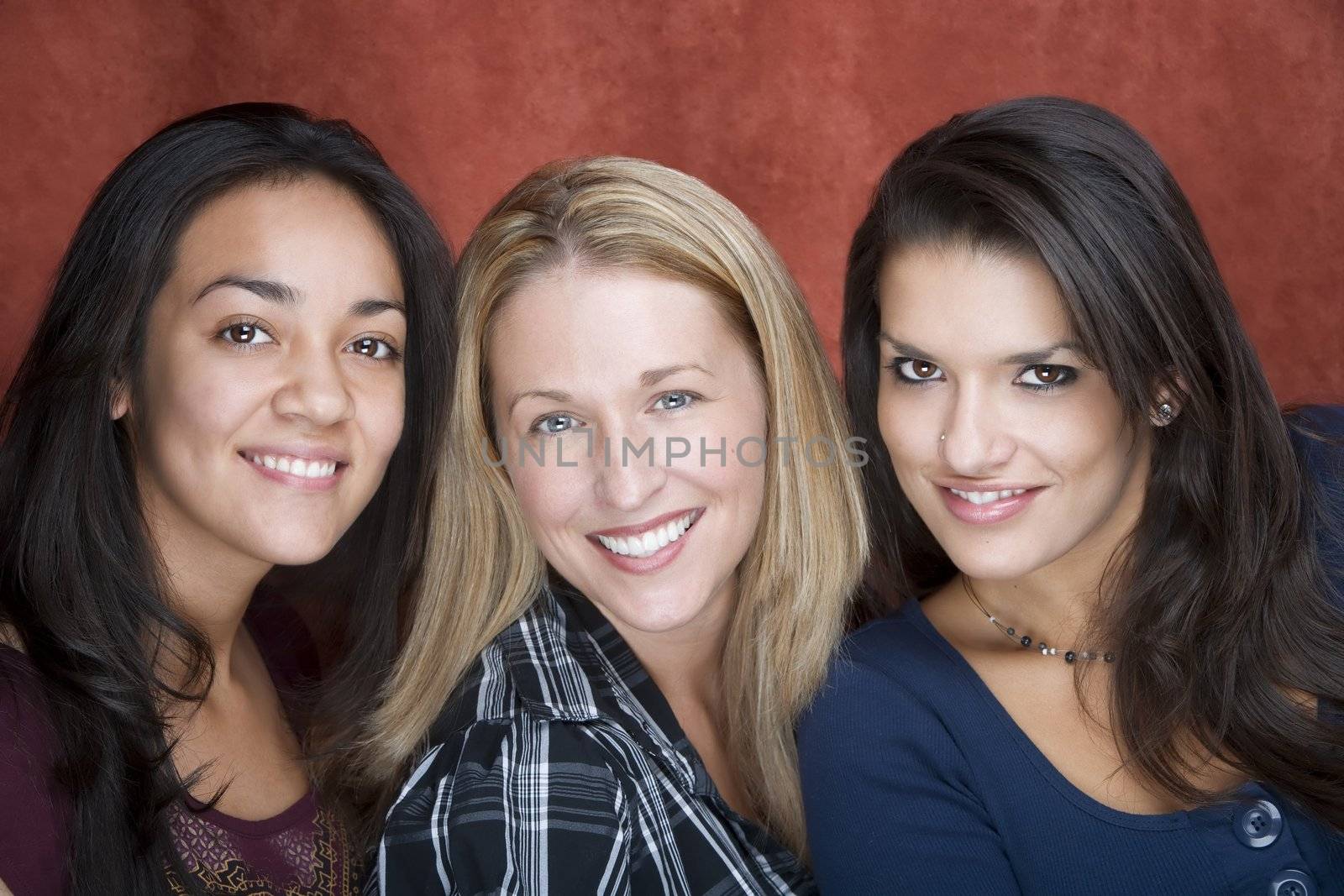 Three pretty women smiling in a studio setting