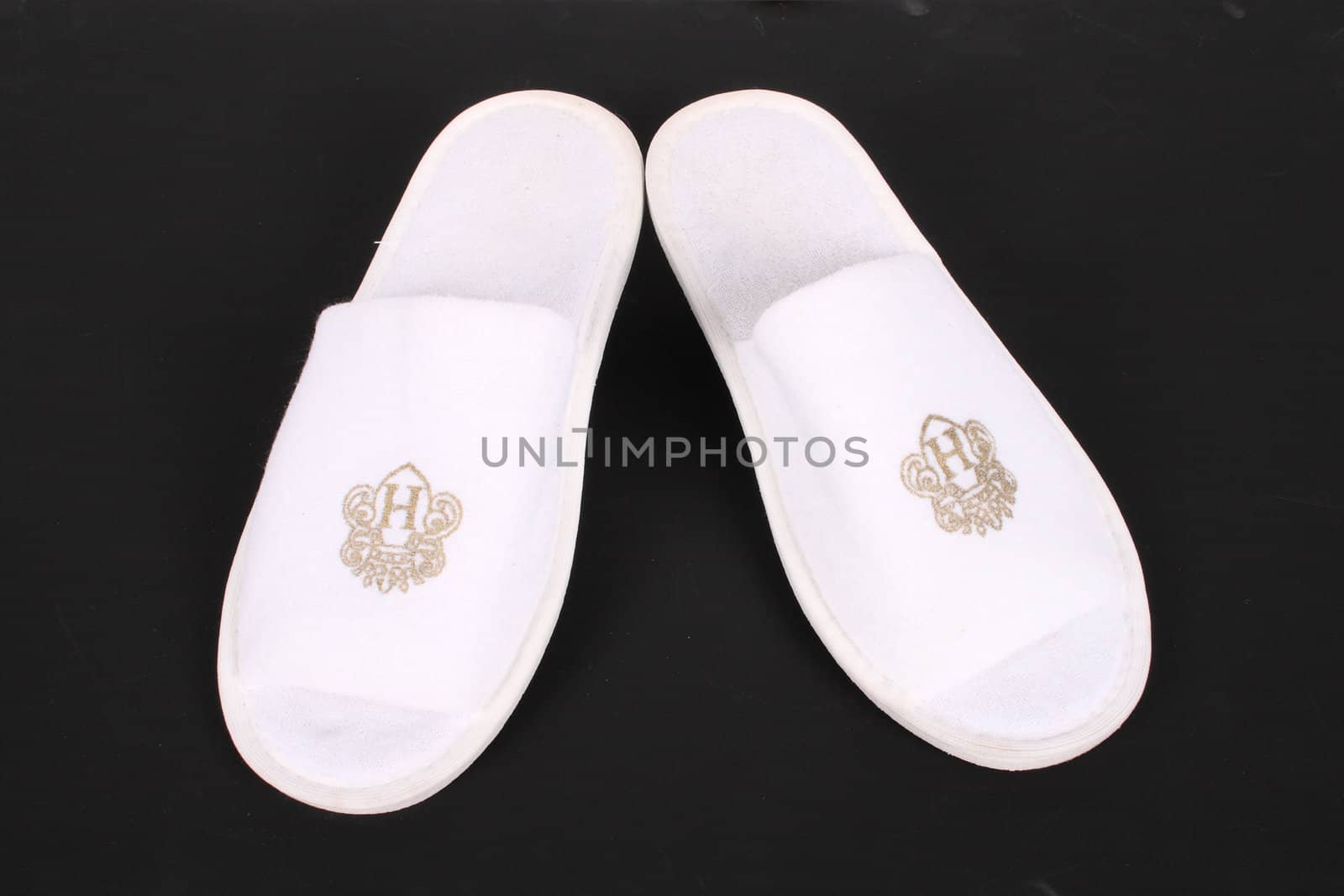 pair white hotel slippers isolated over black