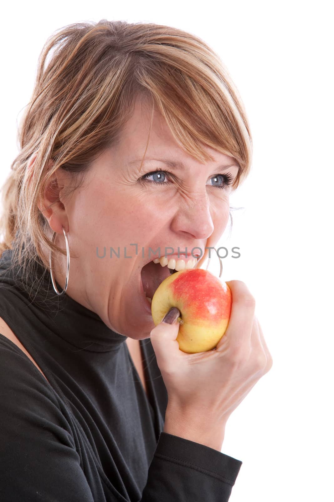 Pretty blond girl biting in an apple