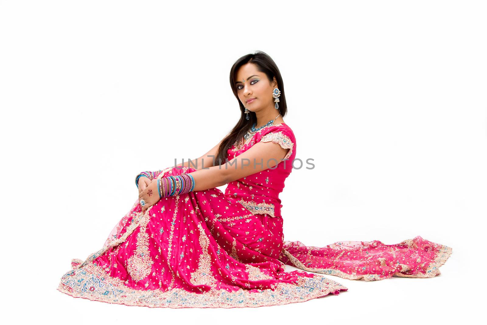 Beautiful Bangali bride in colorful dress sitting, isolated