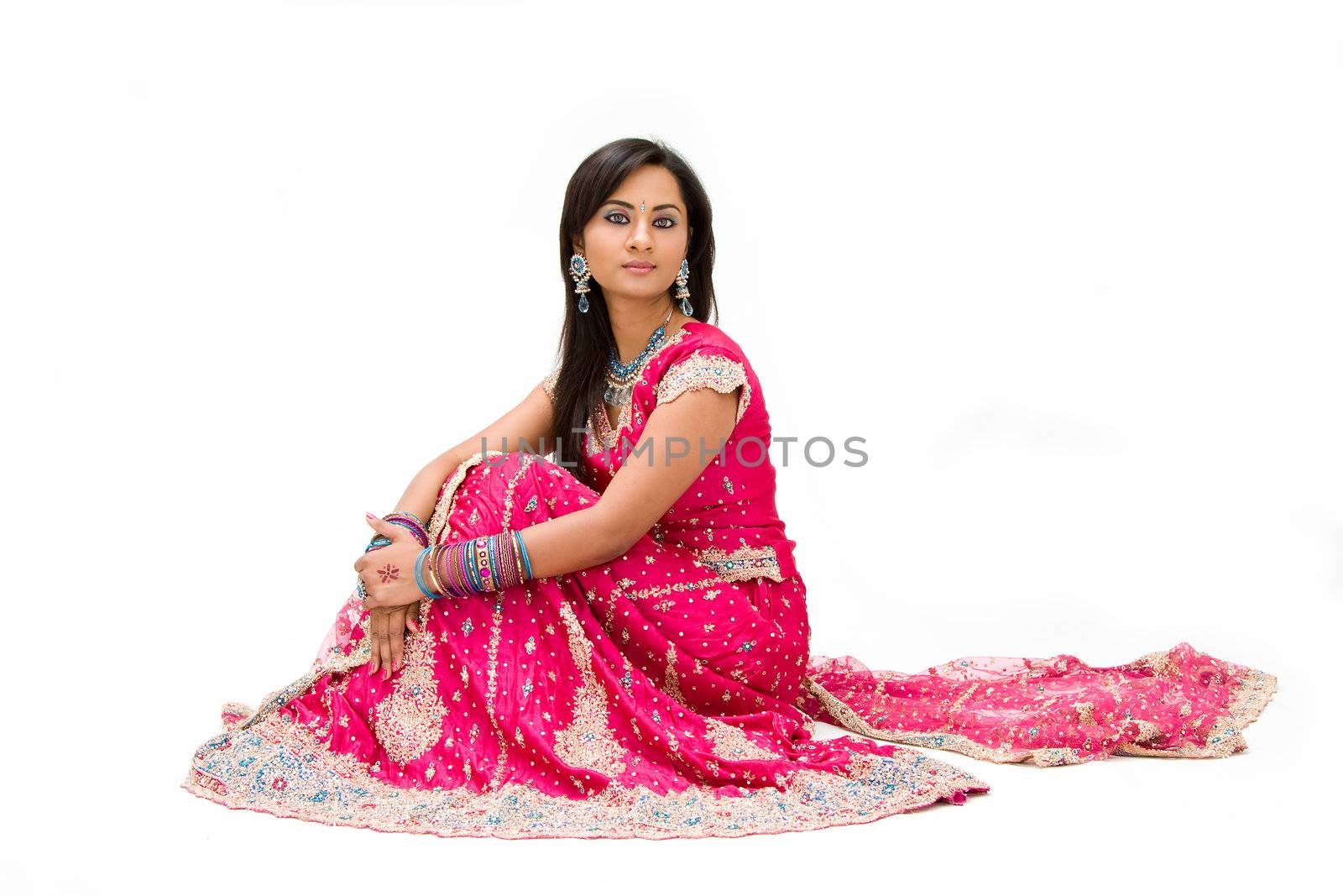 Beautiful Bangali bride in colorful dress sitting, isolated