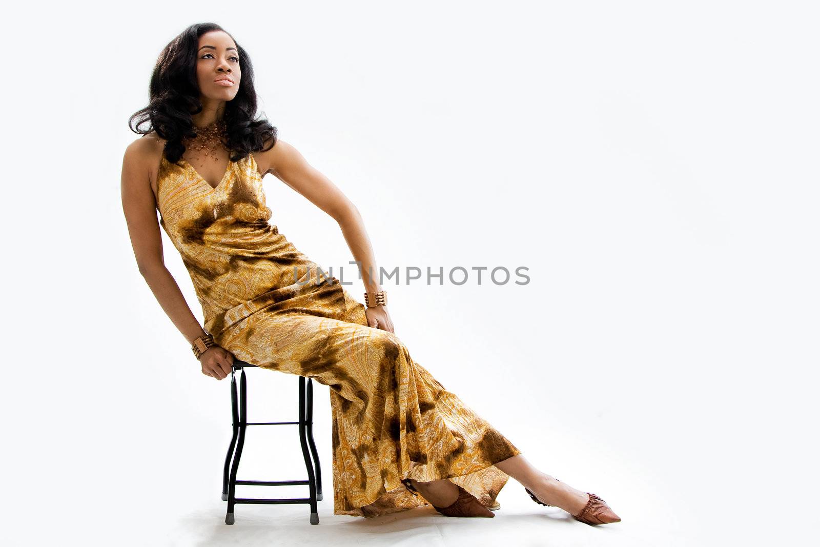 Face of a beautiful African woman sitting on stool looking up, isolated