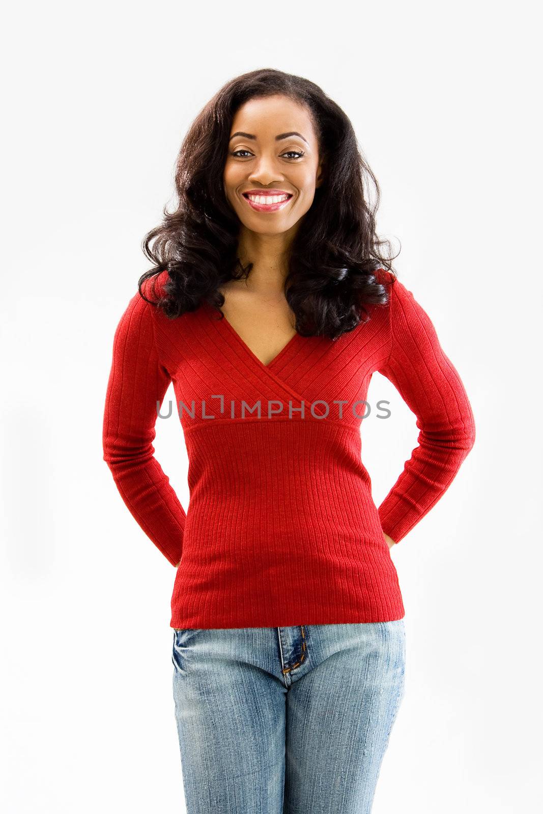 Beautiful African woman standing with hands behind back and smiling, isolated