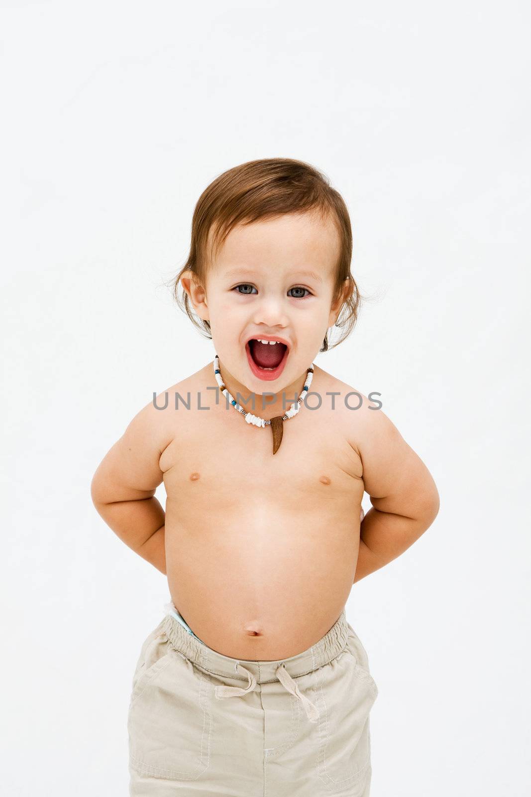 Cute topless toddler boy with necklace open mouth and hands behind back, isolated