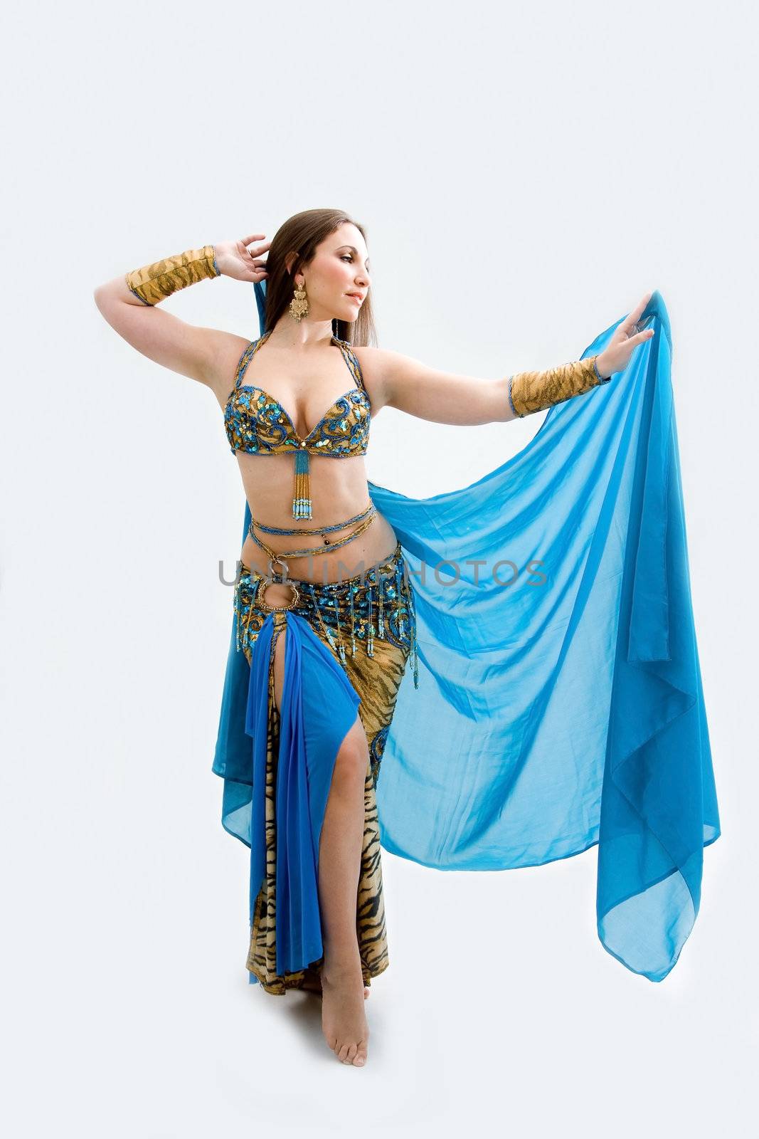 Beautiful belly dancer in blue outfit holding veil, isolated