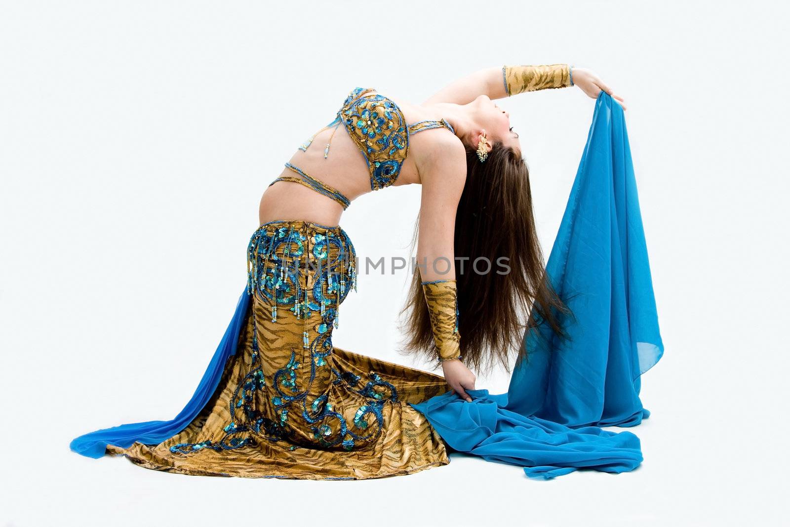 Beautiful belly dancer in blue outfit holding veil bending backward, isolated