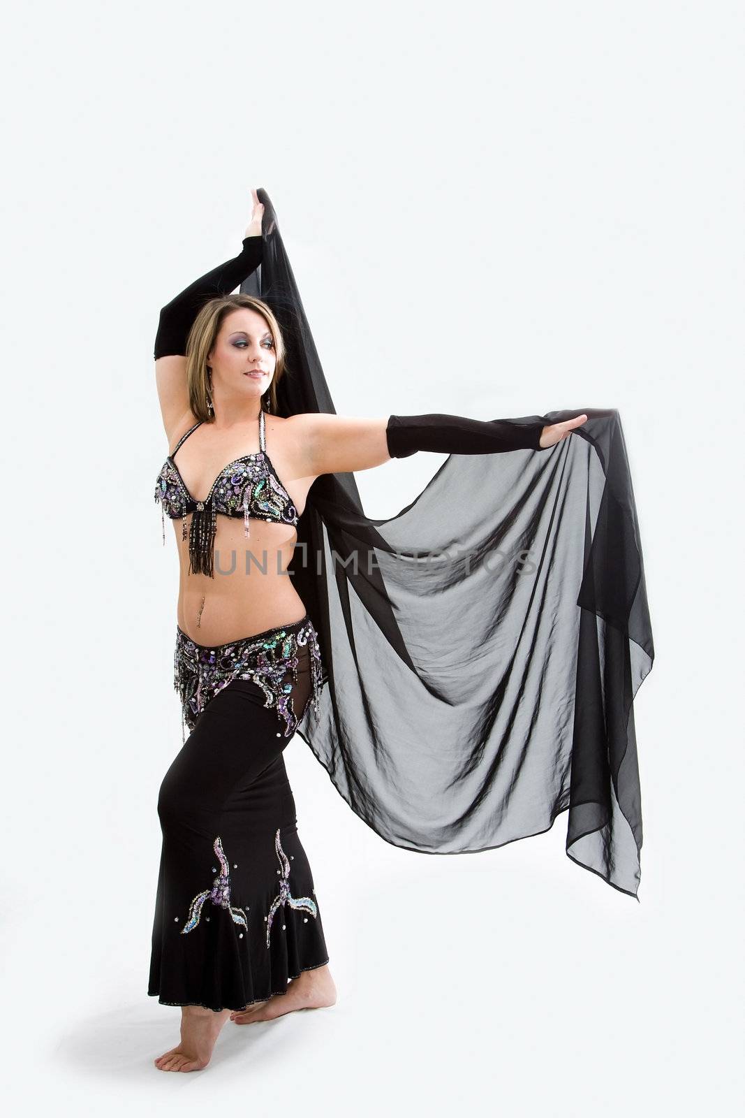 Beautiful belly dancer in black outfit holding veil, isolated