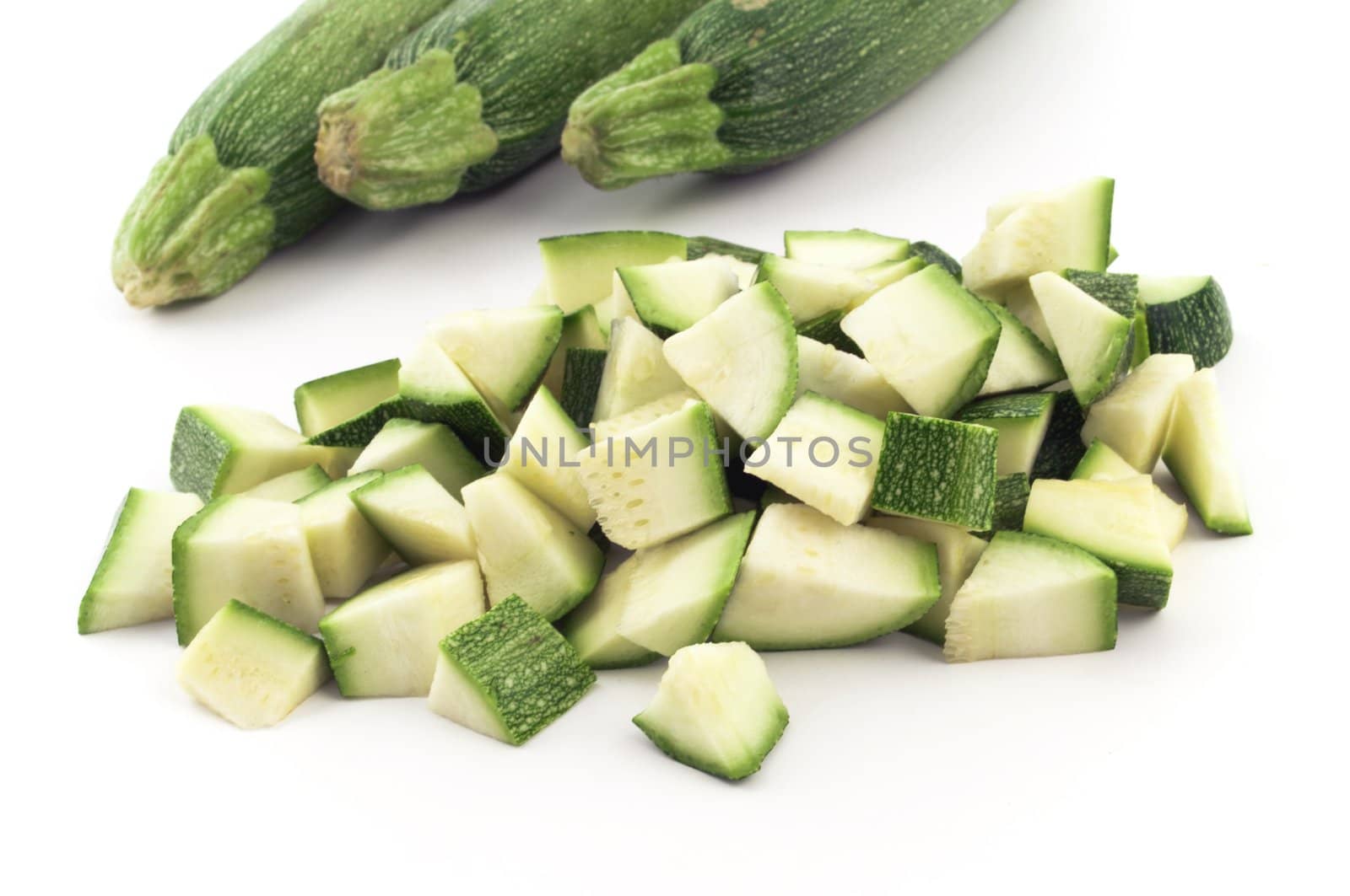 Three zucchini and some pieces of it isolated on white