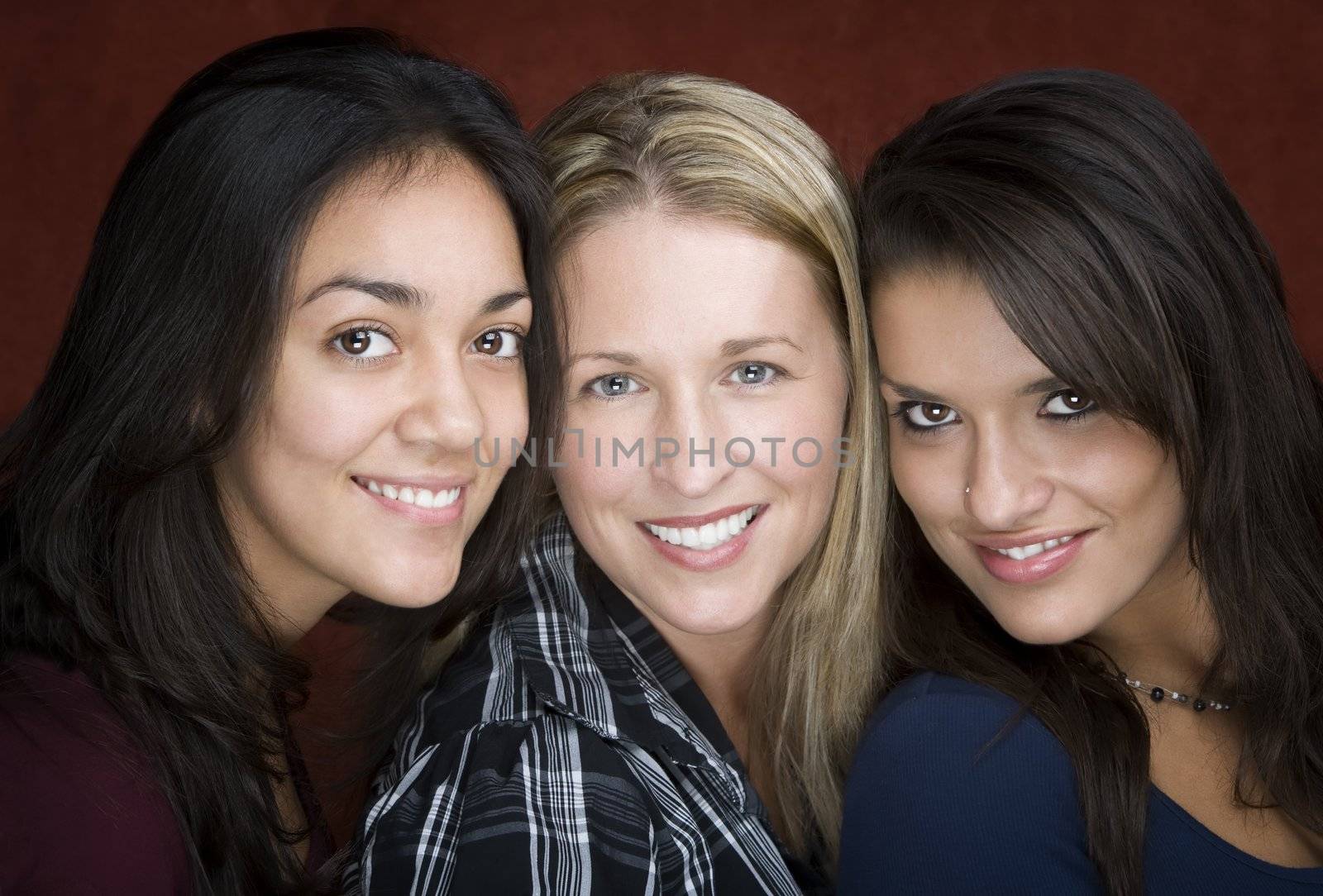 Three smiling young women in a studio setting