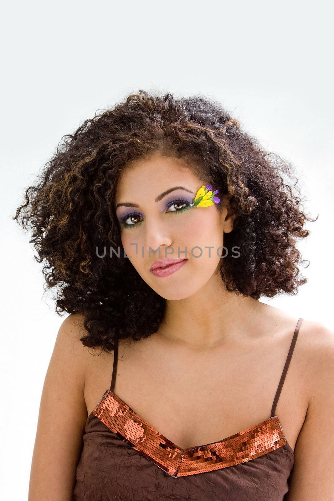 Beautiful brunette in brown shirt with yellow flower and purple eyeshadow, isolated