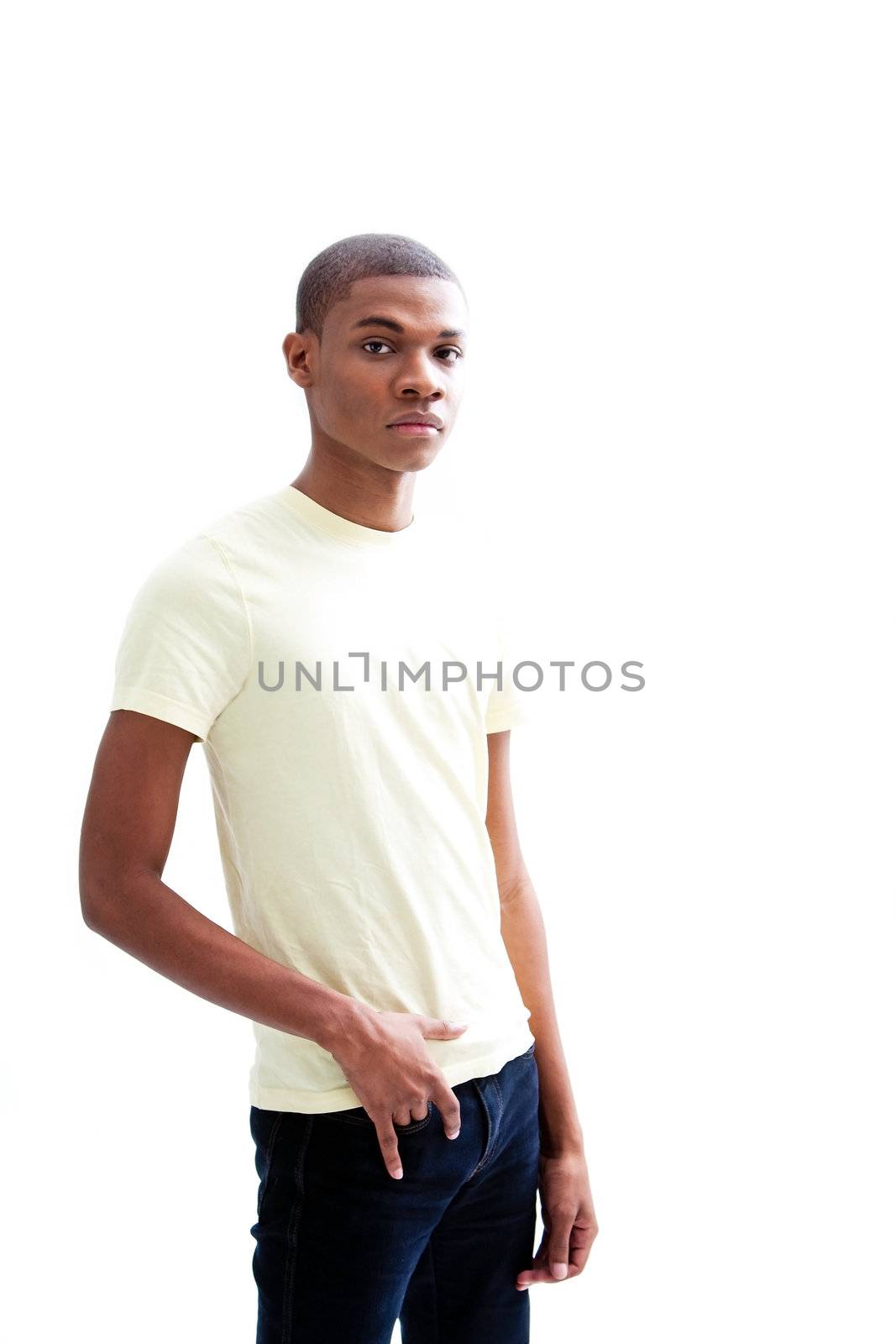 Casual young African man in yellow shirt and hand in pocket of jeans, isolated