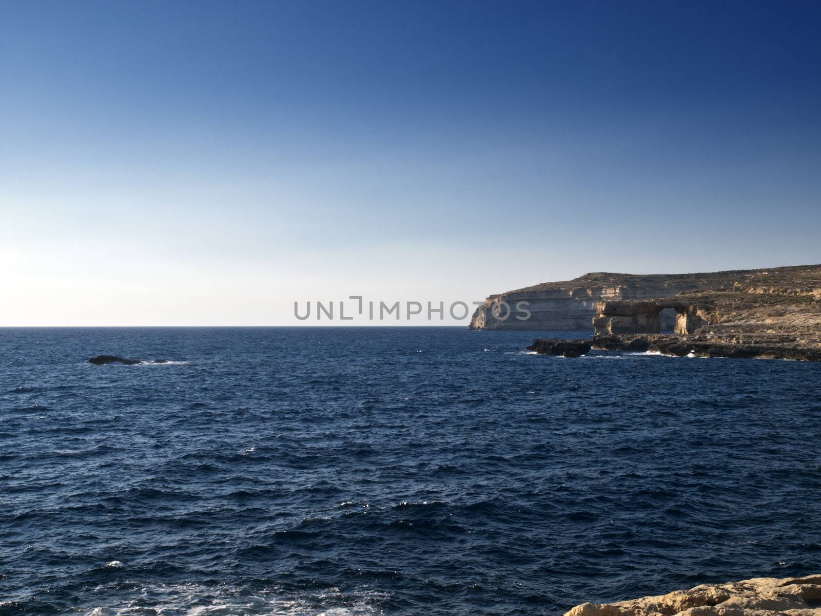 A seascape from Dwejra in Gozo showing Crocodile Rock on the left and the Azure Window on the right