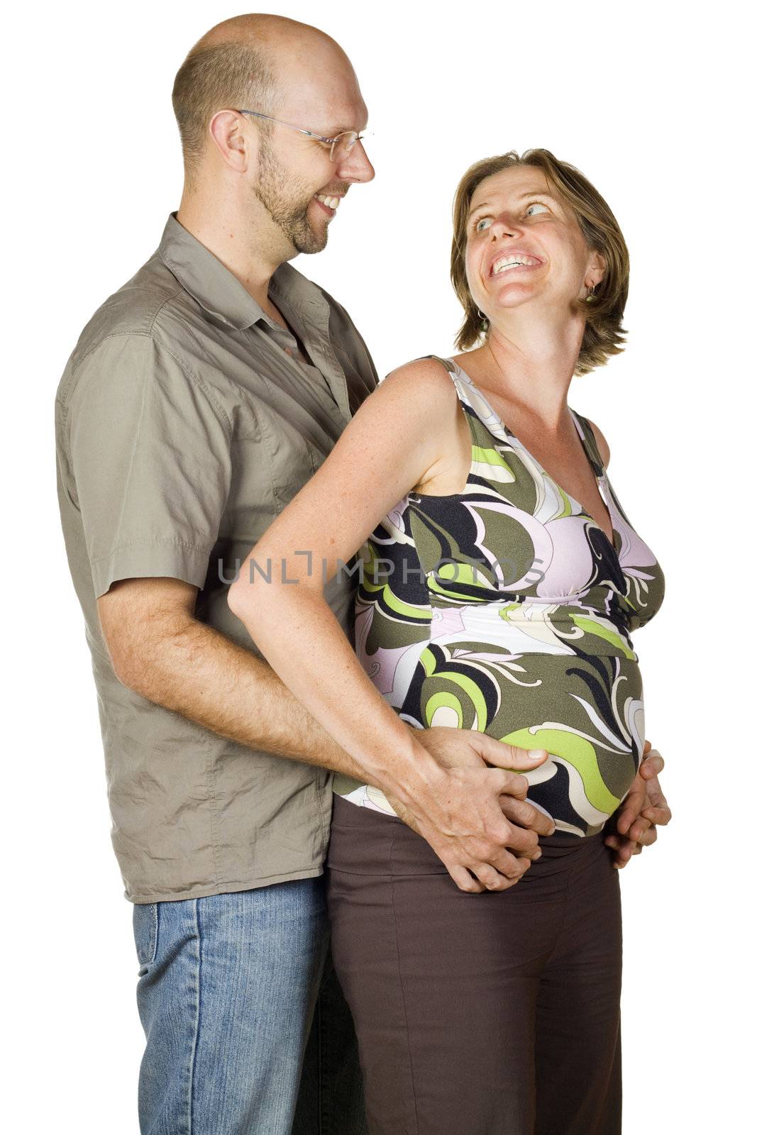 A very nice portrait of a pregnant couple in love, holding hands and looking at eachother. Isolated over white.