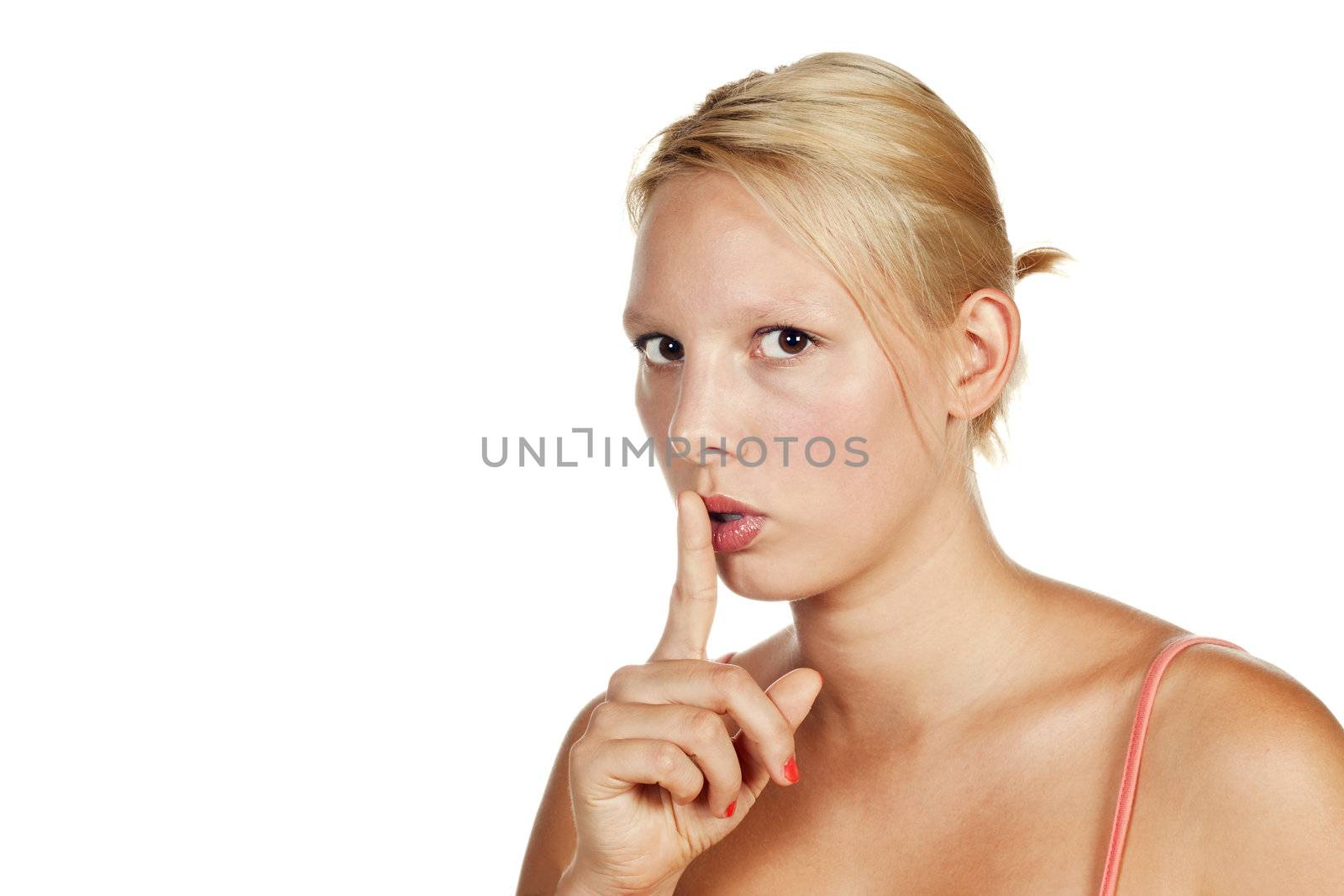 Portrait of an attractive young blonde girl hushing. Isolated over white.