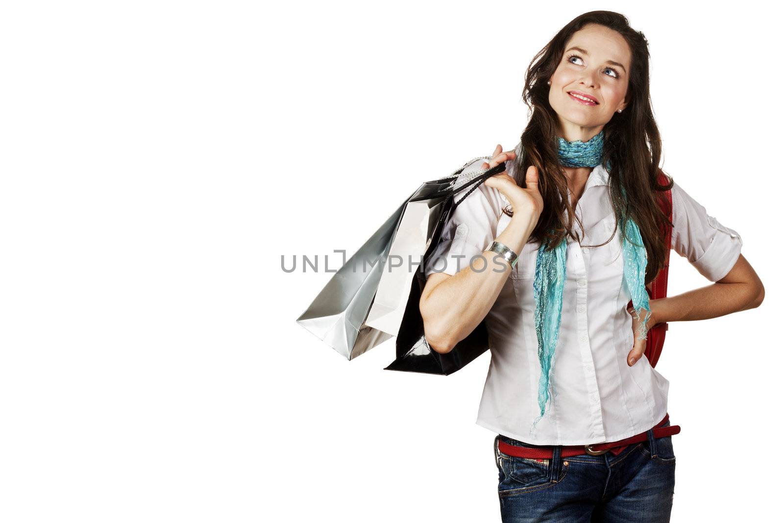 A young attractive woman holding shopping bags and looking contemplative. Isolated over white.