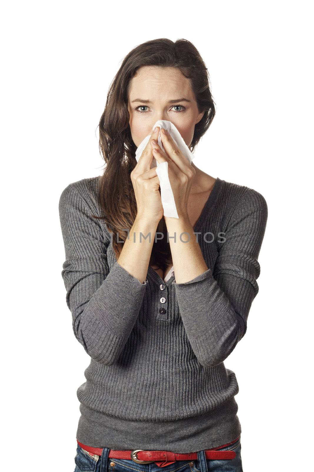A woman with a cold or allergy wiping or blowing her nose.